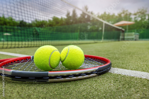 tennis racket and balls on synthetic grass outdoor court