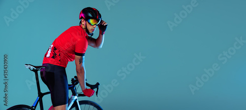 Flyer with professional cyclist on bicycle wearing red sports uniform, goggles and a helmet on a blue background. Concept of active life, rest, travel, energy, sport