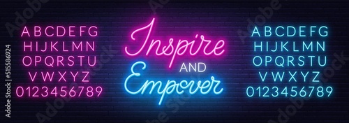 Inspire and Empower neon sign on brick wall background.