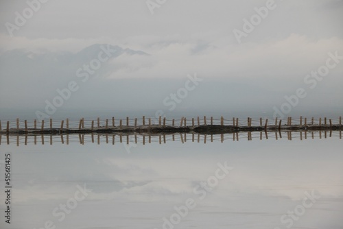 Breathtaking view of a dock on cloudy sky background ideally reflected in water