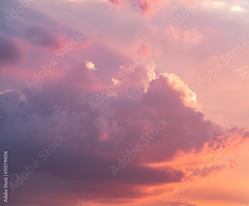 Cloudy sky during thunderstorm. Cumulus clouds shines orange and pink at the horizon during the weather changes. Weather, clouds, temperature and meteorology.