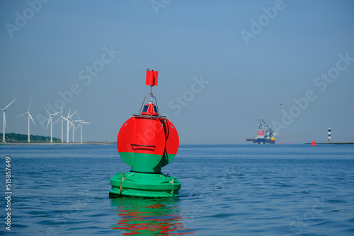 Green red buoy to mark a split in the canal Nieuwe Waterweg in the harbor of Rotterdam.