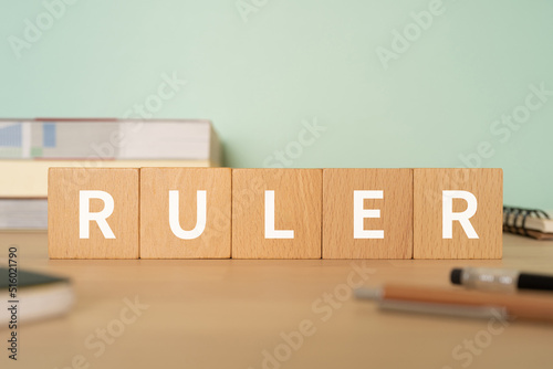 支配者、定規のイメージ｜「RULER」と書かれたブロックが置かれたデスク 