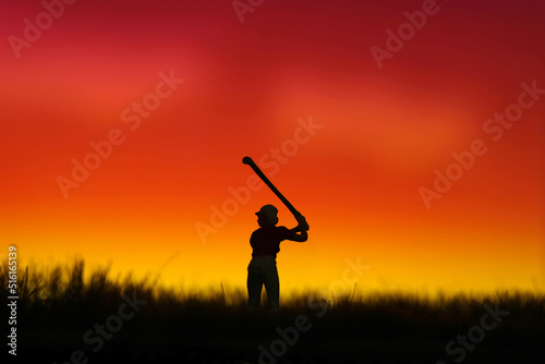 Miniature people toy figure photography. Silhouette of women golfer swing his stick at meadow field hill when sunset sunrise.