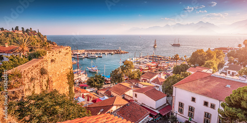 Aerial sunset view of the picturesque harbor with marina port with cruise tourist ships and ancient fortress walls in Antalya. Turkish Riviera and resort paradise