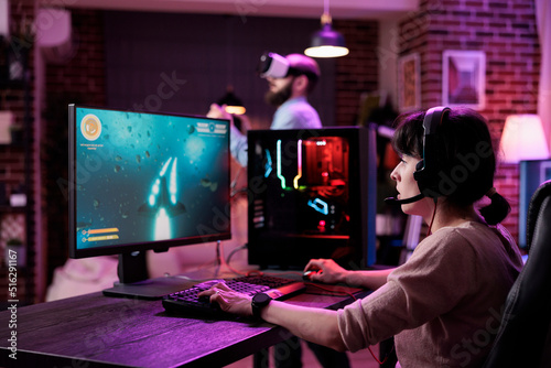 Female gamer live streaming video games play on computer, having fun with rpg tournament. Young adult playing online action shooting game with multiple players on pc, shooter challenge.