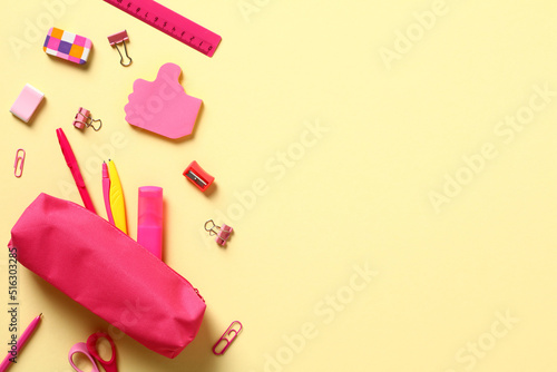 Back to school concept. Flat lay pink school supplies and pencil box on yellow background.