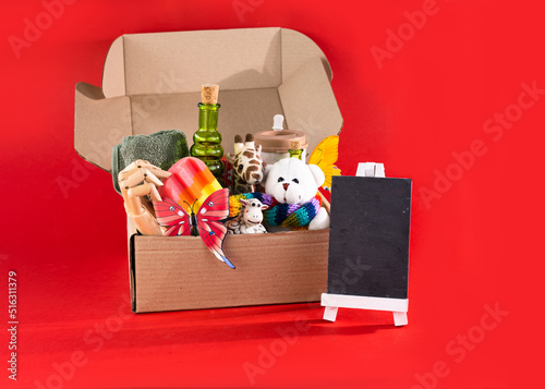 Concept for National Give Something Away Day. Various toys and gifts in a craft box. Donation box. Garage sale.