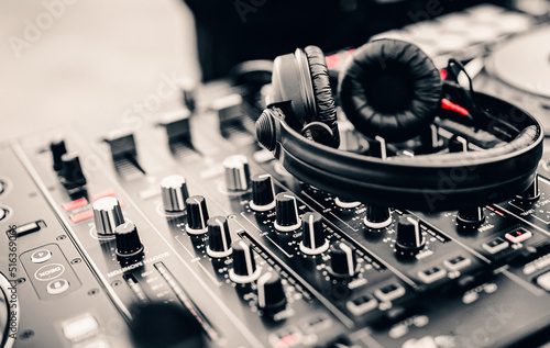 Black headphones for professional Dj on dj console mixer in concert outdoor