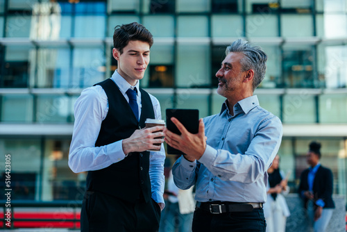 Senior and junior managers talking outdoors