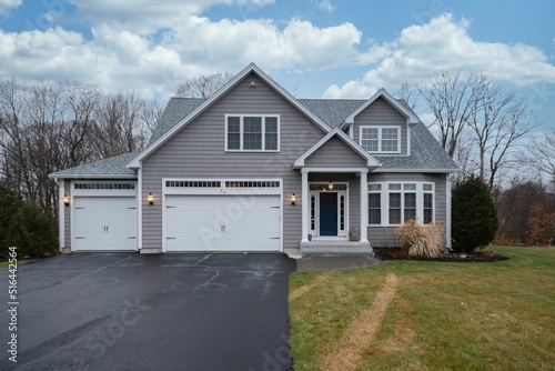 Gray-walled suburban house with white asphalt driveway