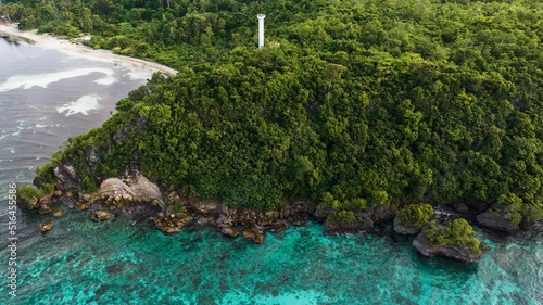 Aerial view of blue water surrounding a beautiful green island