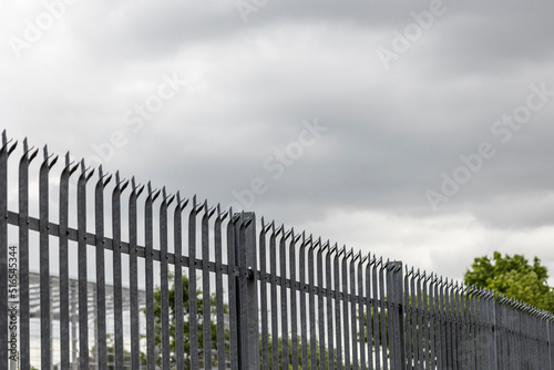 Galvanized steel palisade fence on the border of a property