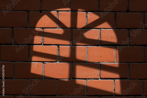 Shadow on the wall, old red brick wall with shadow of a transom window.