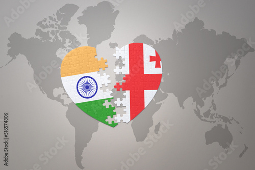 puzzle heart with the national flag of india and georgia on a world map background.Concept.