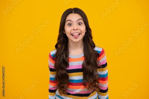 Funny kids face. Portrait of silly teenager child girl smiling and showing tongue in camera making funny faces.