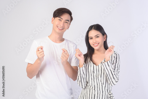 Young smiling man amd woman holding invisalign braces over white background studio, dental healthcare and Orthodontic concept..