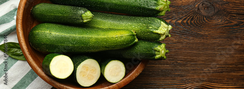 Bowl with fresh zucchini on wooden background. Banner for design