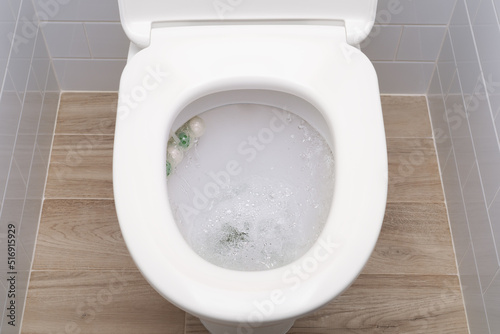 Water flushing in toilet bowl with sanitizing wc balls.