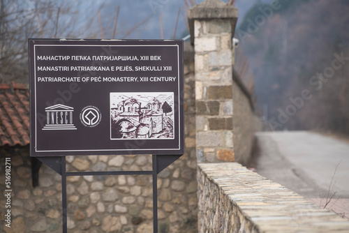 Table sign and Entrance gate to Medieval Monastery and Church Pecka Patrijarsija, main Serbian orthodox monastery and patriarchate. UNESCO world heritage site in Pec, Kosovo, Serbia 05.03.2022