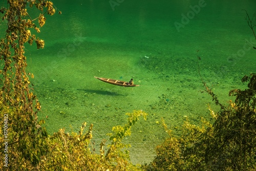 Clear river Dawki in Meghalaya India with a person sitting on a boat