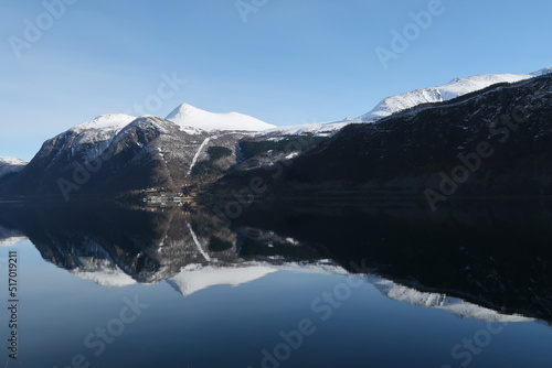 Mountains and forests reflecting in fjord in Norway