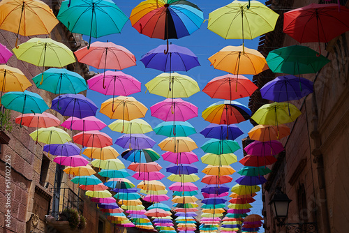 Colourful umbrellas hanging over a picturesque street in the city
