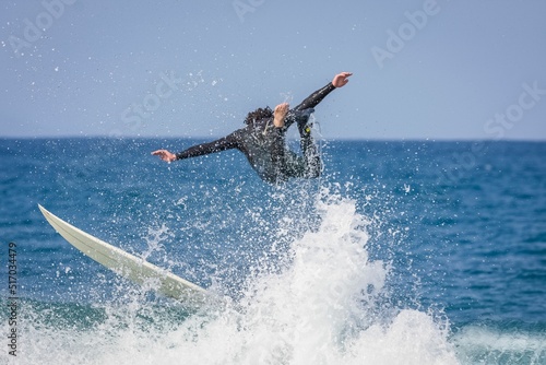 Surfer riding a point break waves and being wipeout in Jeffreys Bay, South Africa