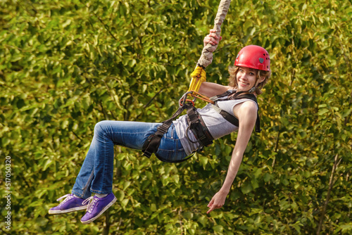 Young woman after the bungee jump against green foliage