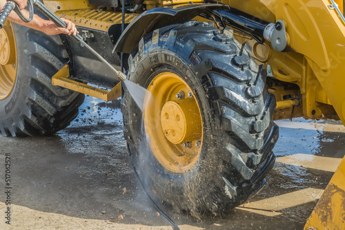 Washing a wheeled tractor at a car wash with a foam solution