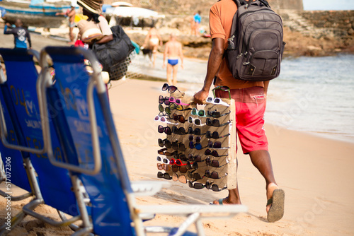 Street vendors walk on the sand of Porto da Barra beach