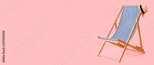 Beach deck chair and hat on pink background with space for text