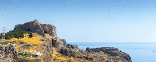 Lindos, with its ancient acropolis, ruins fortress and closed bays in sea coast, is the most view place of Rhodes island in Dodecanese, Greece. Vacation on Greece islands in Mediterranean sea.