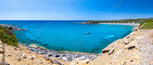 Crystal clear turquoise water in a Glystra bay. Cane umbrellas and sunbeds on an beach resort - vacation concept on Greece islands in Aegean and Mediterranean sea. Near Lindos at east Rhodes. Greece