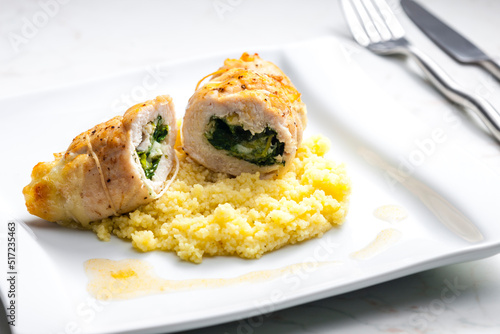 poultry roulade filled with spinach and cheese served with couscous