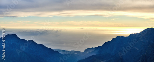 Beautiful landscape of a mountain during sunset with a cloudy sky on a summer day. Peaceful and scenic view of peaks during a golden sunrise with copy space. Aerial view of uncultivated nature