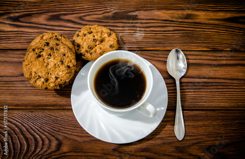 Coffee with biscuits on brown wooden background 