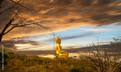 The golden buddha statue on mountain at Wat Khao Wong Phra Chan Temple, Lop Buri, Thailand.