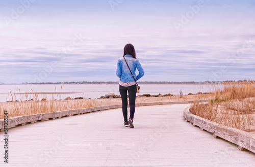 A woman walking on a boardwalk in Milford Connecticut
