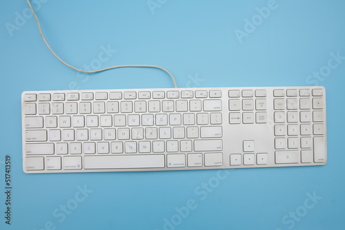 white keyboard blue background viewed from above