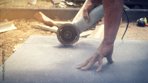 Home renovation, tiler cuts the tile with an angle grinder. Remont domu, glazurnik docina płytkę szlifierką kątową.
