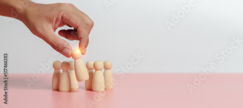 Leadership of teamwork concept. Wooden figures human was chosen leadership of teamwork. man's hands are select wooden puppet to devise strategies for appointing leaders.