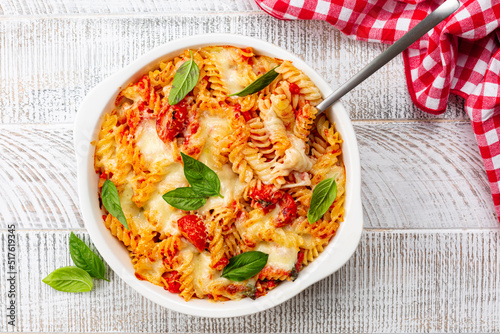Pasta alla sorrentina. Spiral shape fusilli pasta oven baked in casserole with tomato sauce, basil and mozzarella, parmigiano cheese. Italian meal, Campania region.