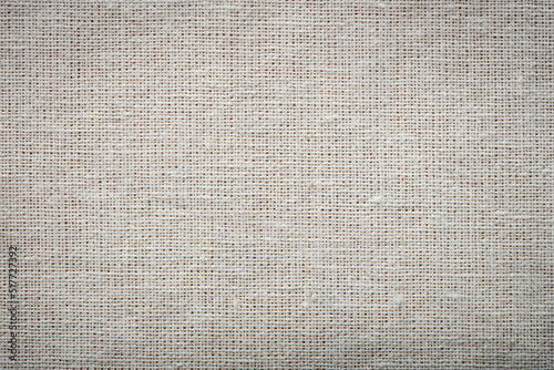 Burlap linen weave fabric background. Sackcloth material. Natural woven rustic bagging material. Light textile texture. Sacking linen fabric pattern. Closeup top view.