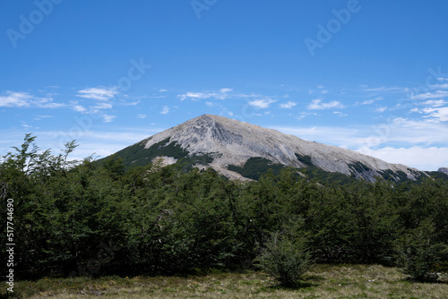 Hiking in a sunny day. View of the mountain and forest under a blue sky. 