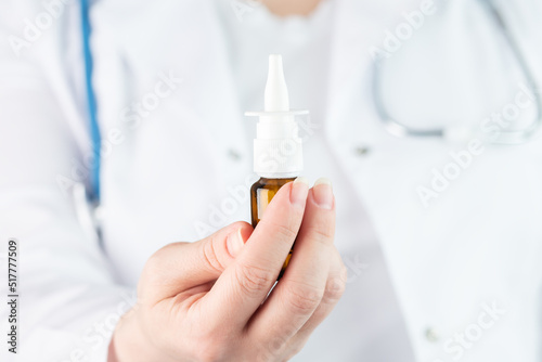 nasal spray in the hands of a doctor in a medical clinic, treatment of a runny nose with medications, drops for nose