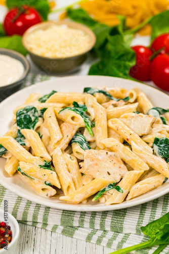 Chicken Alfredo Parmesan Penne Pasta with Spinach. Selective focus.