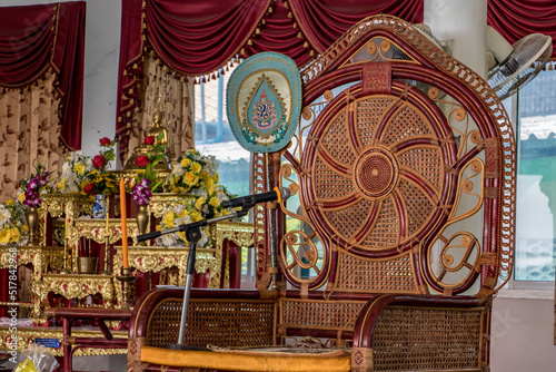 The empty decorative chair for the abbot of Buddhist monastery with microphone ready for ceremonies, Thailand.
