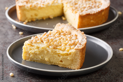 Italian cake covered with pine nuts known as torta della nonna closeup in the plate on the table. Horizontal