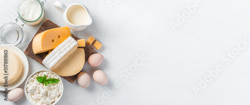 Different types of cheese, cottage cheese, sour cream and eggs on a gray background. A set of dairy products. Top view, copy space